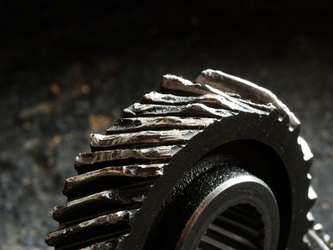 macro shot showing a damaged gear with cracks and dents
