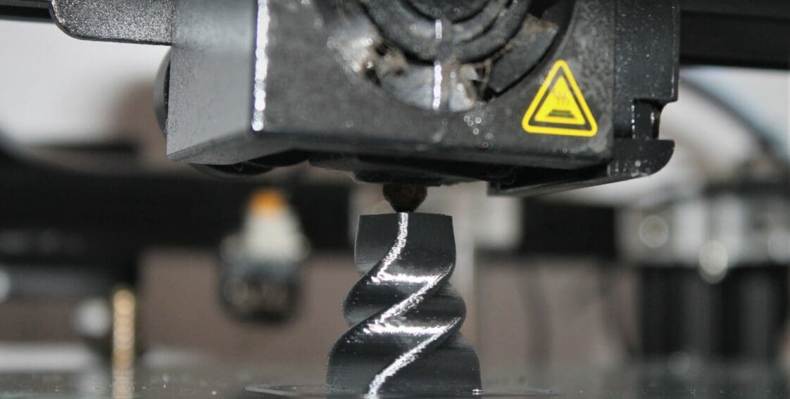 a 3D printing machine creates a twisted steel chess piece